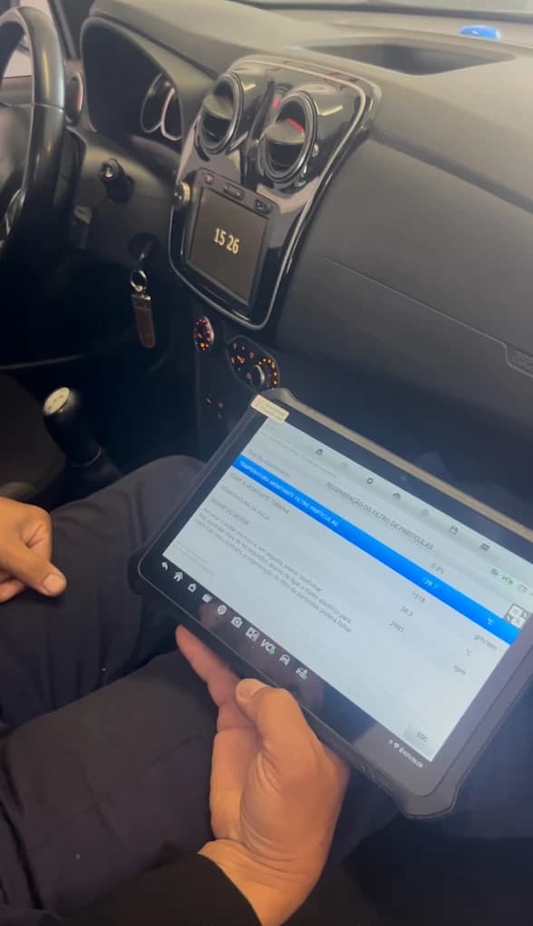 Técnico a usar um tablet de diagnóstico eletrónico dentro de um automóvel
