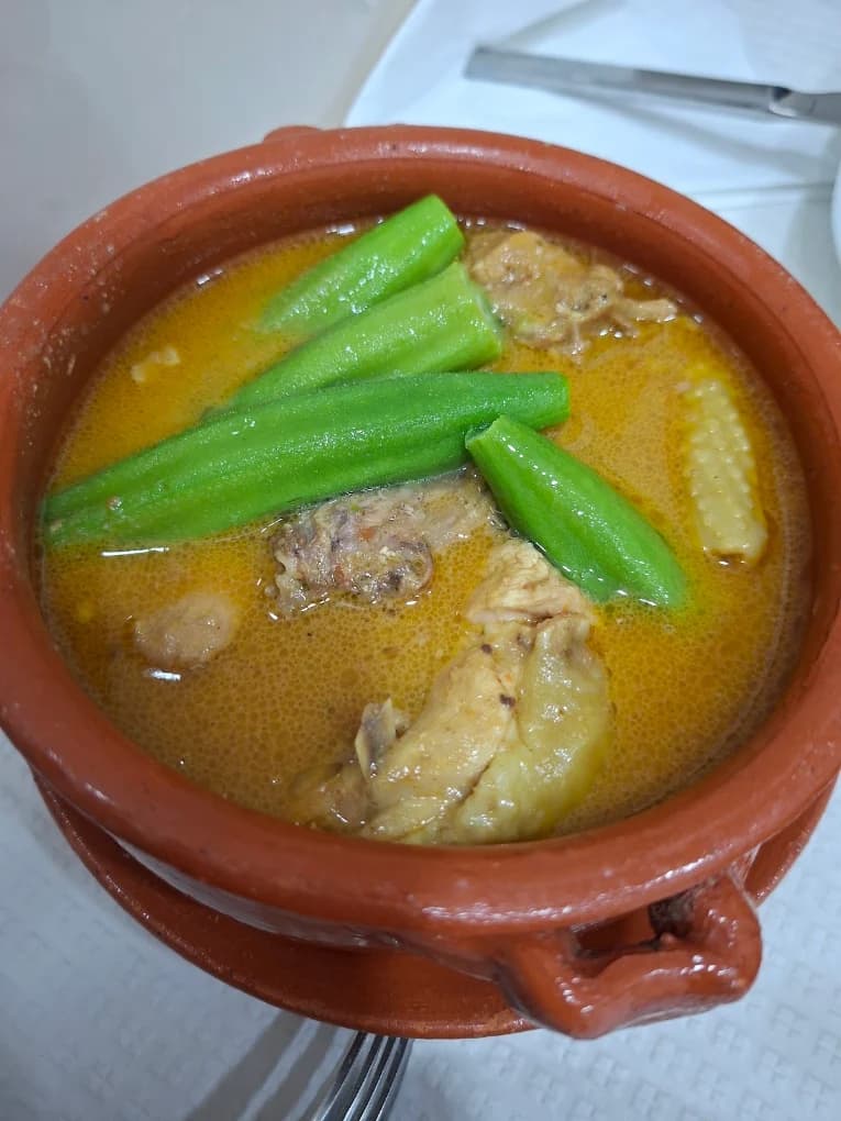 Muamba de galinha com quiabos, servida numa panela de barro