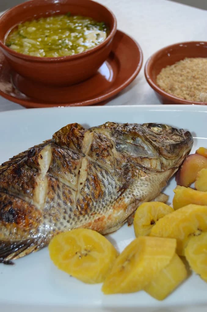 Peixe grelhado inteiro com banana-pão e molho de cebola e salsa
