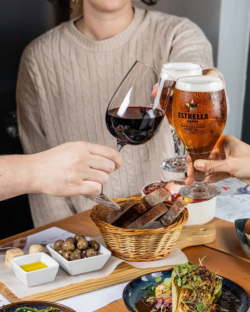 Brinde com vinho tinto e cerveja Estrella Damm, com pão e azeitonas à mesa